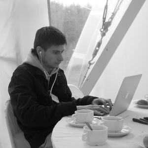 Young man workign on a laptop, dining table with 3 cups of coffee